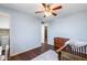 Cozy bedroom featuring a baby crib, a ceiling fan, and a view into the closet at 31332 N 137Th Ln, Peoria, AZ 85383