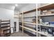 Organized storage closet with multiple shelves and wooden supports for storage items at 31332 N 137Th Ln, Peoria, AZ 85383
