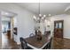 Well-lit dining area featuring a chandelier and dining table adjacent to multiple entryways at 31332 N 137Th Ln, Peoria, AZ 85383