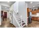 Bright entryway featuring staircase, view to kitchen with stainless fridge and decorative foyer table at 31332 N 137Th Ln, Peoria, AZ 85383