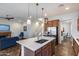 Open concept kitchen with island, stainless steel appliances, and seamless flow to living space at 31332 N 137Th Ln, Peoria, AZ 85383