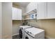 A well-organized laundry room with modern washer and dryer, storage cabinets, and shelving at 31332 N 137Th Ln, Peoria, AZ 85383