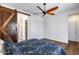 Main bedroom featuring hardwood floors, fan, and a barn door to the walk-in closet and ensuite bathroom at 31332 N 137Th Ln, Peoria, AZ 85383
