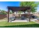 Backyard pergola with a dining table, sofa swing, and potted plants at 31332 N 137Th Ln, Peoria, AZ 85383