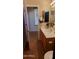 Bathroom featuring a single sink vanity, adjacent room with window, and neutral color palette at 3247 E Lark Ct, Gilbert, AZ 85297