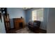 Bedroom features blue walls, a window, a rolltop desk, and a comfortable recliner with ottoman at 3247 E Lark Ct, Gilbert, AZ 85297