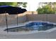Backyard pool with rock landscaping, waterfall feature, and dark blue umbrellas for shade and relaxation at 3247 E Lark Ct, Gilbert, AZ 85297