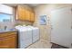 Well-lit laundry room with cabinetry, sink and modern washer and dryer for efficient laundry care at 32826 N 54Th St, Cave Creek, AZ 85331