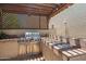 Outdoor kitchen featuring a built-in stainless steel grill, countertop space, and a wood pergola at 32826 N 54Th St, Cave Creek, AZ 85331