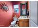This unique powder room features colorful walls, decorative mirror and a classic toilet and vanity at 32826 N 54Th St, Cave Creek, AZ 85331