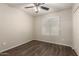 This bedroom features modern wood floors, a ceiling fan, and a bright window at 36538 W La Paz St, Maricopa, AZ 85138
