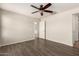 Bright bedroom with wooden flooring, ceiling fan and adjacent ensuite bathroom at 36538 W La Paz St, Maricopa, AZ 85138