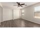 Bedroom featuring wood flooring, ceiling fan, and a large window with blinds at 36538 W La Paz St, Maricopa, AZ 85138