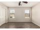 Empty bedroom featuring wood floors, neutral walls, ceiling fan, and bright windows at 36538 W La Paz St, Maricopa, AZ 85138