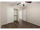 Bedroom with wood floor, ceiling fan, closet, and ensuite bathroom access at 36538 W La Paz St, Maricopa, AZ 85138