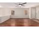 Spacious living room featuring hardwood floors, large windows, and a ceiling fan at 36538 W La Paz St, Maricopa, AZ 85138