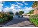 Beautiful community pool with lush landscaping, lounge seating, and a bright blue sky with puffy clouds above at 4016 W Royal Palm Rd, Phoenix, AZ 85051