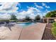 Community swimming pool featuring clear blue water, lounge chairs, and well-maintained landscaping under a partly cloudy sky at 4016 W Royal Palm Rd, Phoenix, AZ 85051