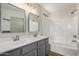 Well-lit bathroom featuring a double sink vanity, framed mirrors, and a shower over tub at 4031 W Lone Cactus Dr, Glendale, AZ 85308
