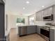 Modern kitchen featuring gray cabinets, stainless steel appliances, and wood-style floors at 4031 W Lone Cactus Dr, Glendale, AZ 85308