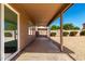 Covered patio area with sliding glass doors leading to a gravel yard and distant greenery at 4031 W Lone Cactus Dr, Glendale, AZ 85308