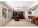 Sunlit home office boasts built-in shelving, a large desk, and a comfortable piano, offering ample workspace at 4102 E Palm Beach Dr, Chandler, AZ 85249