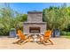 Inviting backyard featuring an outdoor fireplace surrounded by chairs, ideal for entertaining at 4442 E Fairbrook St, Mesa, AZ 85205