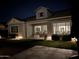 Charming backyard with patio, outdoor seating, manicured lawn, and stylish home exterior at night at 4442 E Fairbrook St, Mesa, AZ 85205