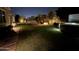 Expansive backyard featuring a fireplace, hot tub, patio and mature landscaping at night at 4442 E Fairbrook St, Mesa, AZ 85205