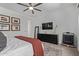 Bedroom featuring a dresser with mounted TV, framed pictures, and ceiling fan at 4442 E Fairbrook St, Mesa, AZ 85205