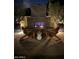 Cozy outdoor fireplace with brick surround and comfortable Adirondack chairs at night at 4442 E Fairbrook St, Mesa, AZ 85205