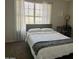 Bright bedroom features a window with sheer curtains, and a full bed with a modern, gray headboard at 4601 N 102Nd Ave # 1052, Phoenix, AZ 85037