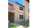 Two-story townhome boasts a stucco exterior, terracotta roof, gated front door, and well-maintained landscaping at 4601 N 102Nd Ave # 1052, Phoenix, AZ 85037