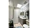 Bathroom with light gray cabinets, tile floors, and a skylight for natural light at 4767 W Wahalla Ln, Glendale, AZ 85308