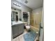Bathroom with light gray cabinets, shower/tub combo with yellow paneling, and a blue accent rug at 4767 W Wahalla Ln, Glendale, AZ 85308