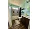 Bathroom with dark wood cabinets, shower/tub combo with gray tile, dark wood floors, and light green walls at 4767 W Wahalla Ln, Glendale, AZ 85308