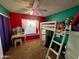 Bedroom with carpet, a bright red accent wall, and a ladder-style bunkbed with a desk underneath at 4767 W Wahalla Ln, Glendale, AZ 85308