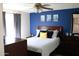 Cozy bedroom with natural lighting, modern ceiling fan, and bright accent wall at 4767 W Wahalla Ln, Glendale, AZ 85308