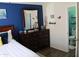 Bedroom with wood floors, a blue accent wall, and a wooden dresser with a large mirror at 4767 W Wahalla Ln, Glendale, AZ 85308