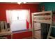 Bedroom with carpet, a bright red accent wall, and a ladder-style bunkbed with a desk underneath at 4767 W Wahalla Ln, Glendale, AZ 85308