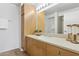Well-lit bathroom vanity with neutral countertops, a large mirror, and cabinet storage at 4808 N 24Th St # 1228, Phoenix, AZ 85016
