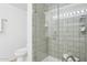 Bathroom featuring a modern shower with glass door, a toilet, and a tiled surround at 4808 N 24Th St # 1228, Phoenix, AZ 85016