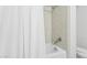 A bathroom bathtub featuring tile walls, a shower head, silver faucet and a white curtain at 4808 N 24Th St # 1228, Phoenix, AZ 85016