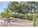 Landscaped backyard featuring gravel, stepping stones, flowering bushes and mature trees providing ample shade at 4928 E Paradise Ln, Scottsdale, AZ 85254