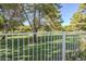Scenic view of a community green space from the backyard, featuring a white fence and mature trees at 4928 E Paradise Ln, Scottsdale, AZ 85254