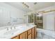 Bathroom with double sinks, a tub, and a glass shower door at 4928 E Paradise Ln, Scottsdale, AZ 85254