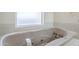 Corner bathtub with hydrotherapy jets and frosted window at 4928 E Paradise Ln, Scottsdale, AZ 85254