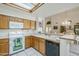 Bright kitchen with oak cabinets, tile countertops, a skylight, and an open view to the dining area at 4928 E Paradise Ln, Scottsdale, AZ 85254