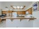 Spacious kitchen featuring light wood cabinets, tile countertops, a central island, and ample natural light at 4928 E Paradise Ln, Scottsdale, AZ 85254