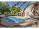 Relaxing backyard features a refreshing pool, lush landscaping, and a covered patio, perfect for outdoor living at 4928 E Paradise Ln, Scottsdale, AZ 85254